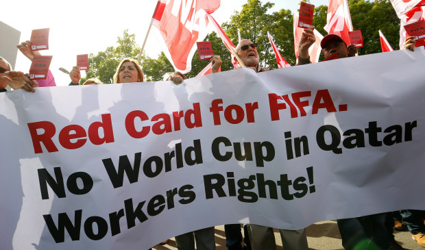 Members of the Swiss UNIA workers union display red cards and shout slogans during a protest in front of the headquarters of soccer's international governing body FIFA in Zurich
