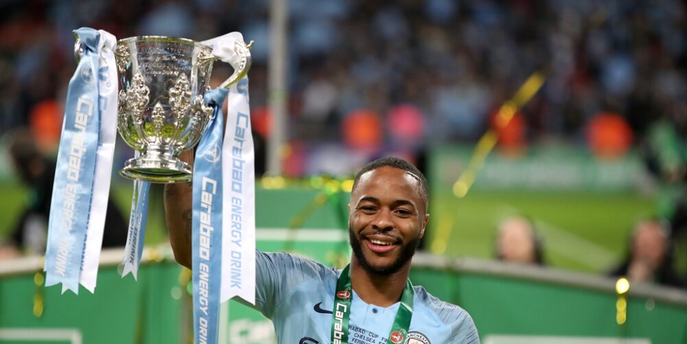 Raheem Sterling lifts the League Cup trophy