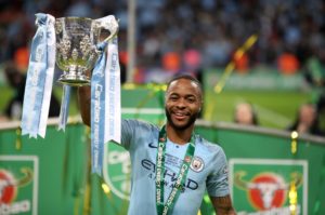 Raheem Sterling lifts the League Cup trophy