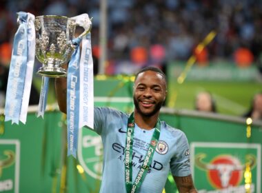 Raheem Sterling lifts the League Cup trophy